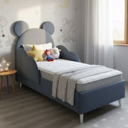 Children's bed with mouse ears in a room decorated with wall stickers.